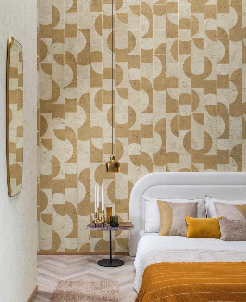 A bedroom with a bed and a wall that has a pattern of different shapes.