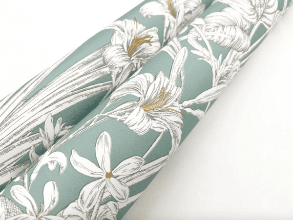 Teal floral wallpaper roll.