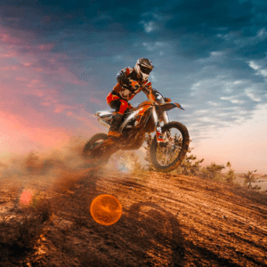 Motocross rider jumps dirt bike sunset.