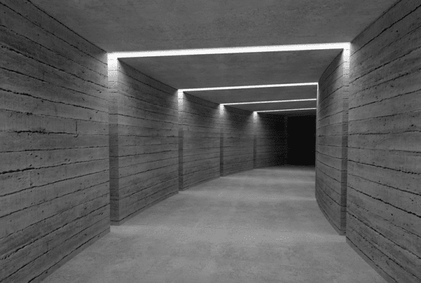 Lit concrete corridor leading to darkness.