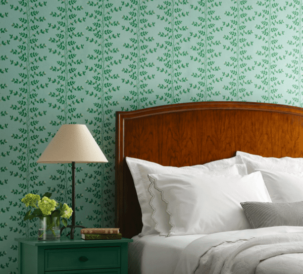 Green leafy wallpaper on bedroom wall.