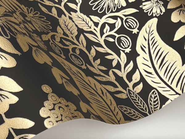 Gold floral wallpaper on black background.