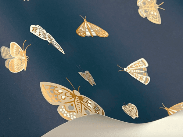 Gold and white moths on navy blue.