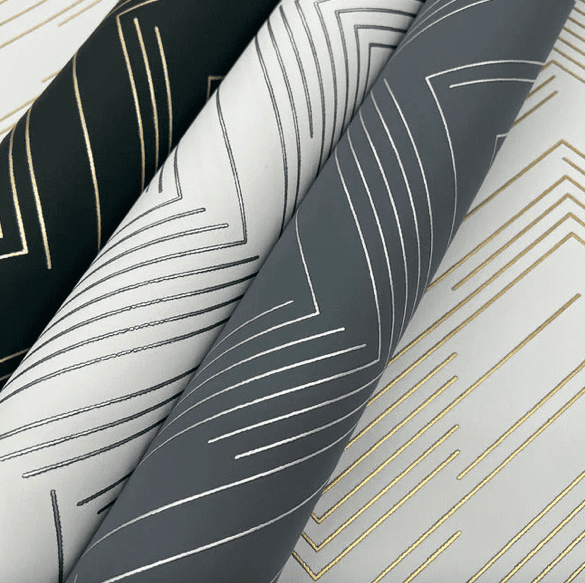 Geometric wallpaper rolls, gold and gray.