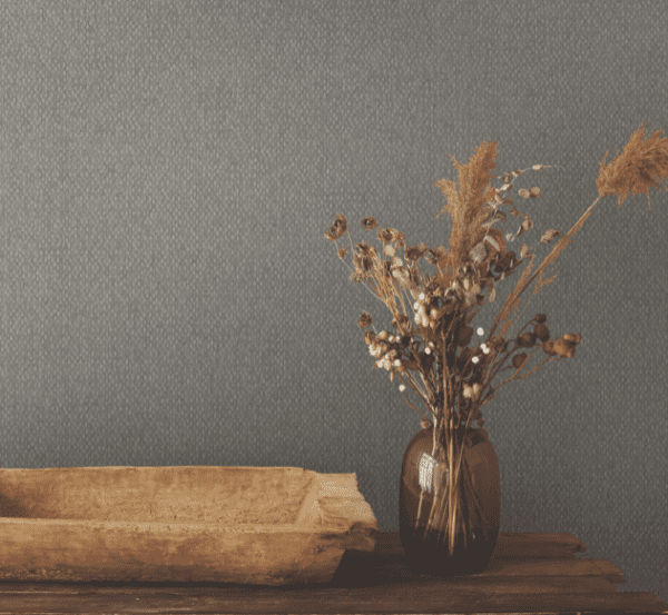 Dried flowers in vase, rustic setting.